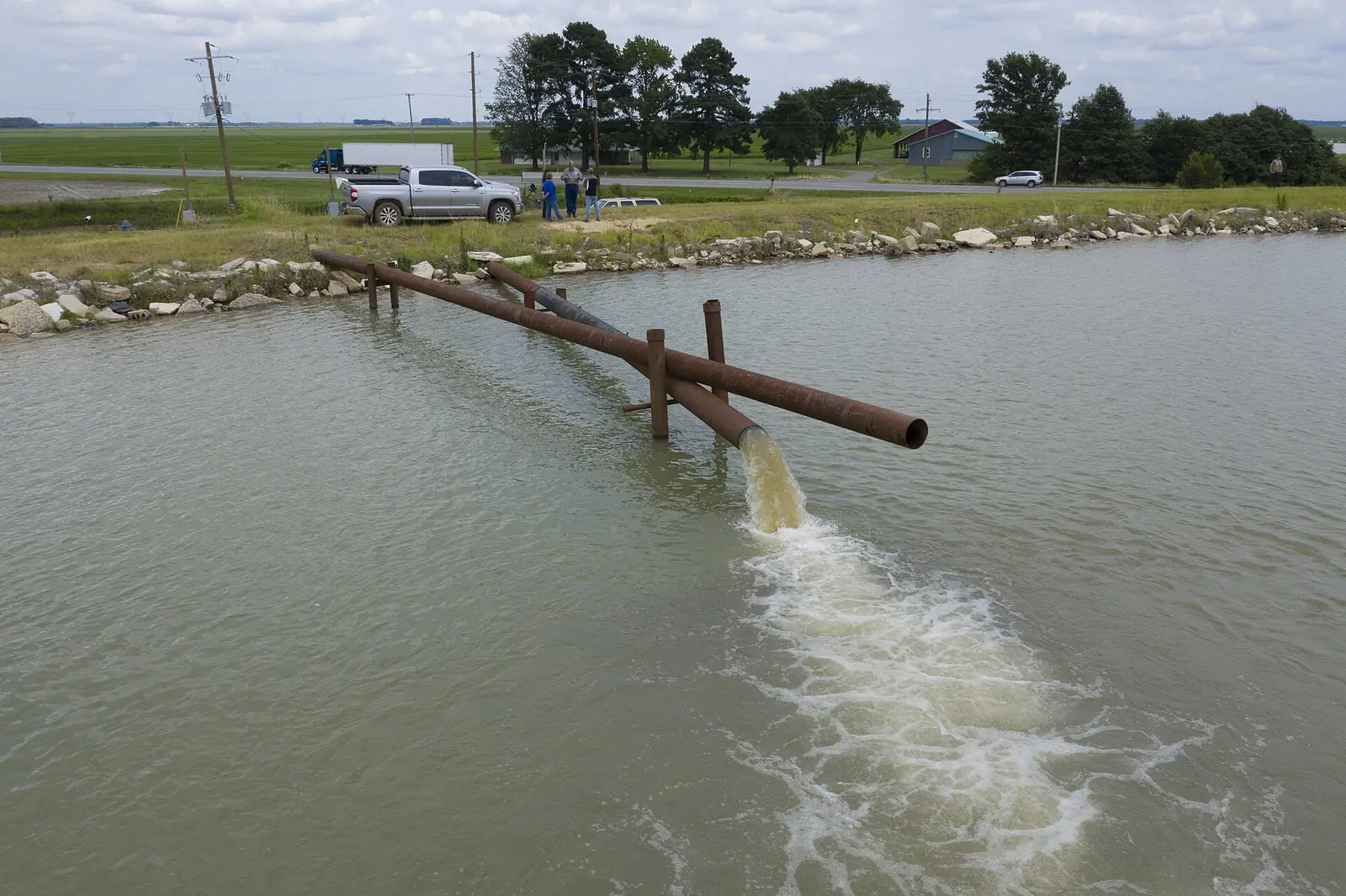 Lagoon with an inflow pipe and rock-lined bank